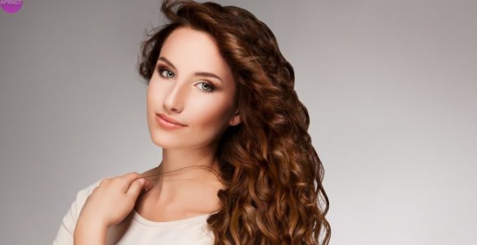 Red Hair. Beautiful Woman with Curly Long Hair. High quality image.